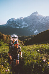 Father hiking with child daughter in backpack family travel vacation outdoor in mountains adventure...