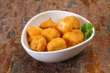 Sweet tasty profiteroles heap in the bowl