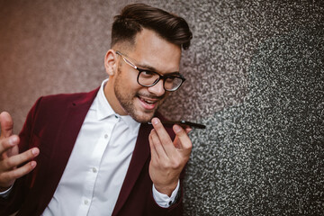Young business man using voice command recorder on smartphone.