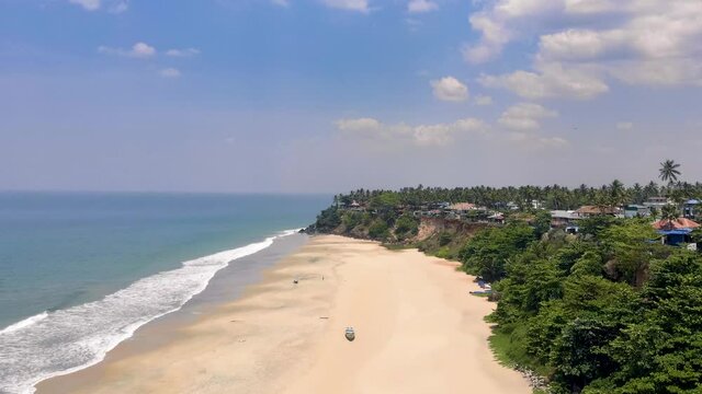 Aerial Hyper-lapse of the famous Beach in Varkala named Papanasam on a midday shot from a high angle with a drone in 4k. Varkala is a beach town located in the Southwest Coasts of Kerala.