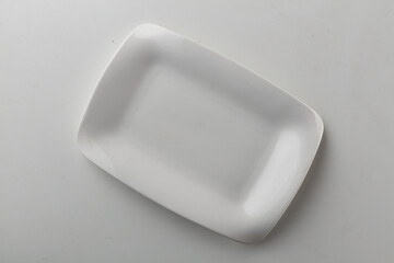 Top view shot of a rectangular white plate on white background.