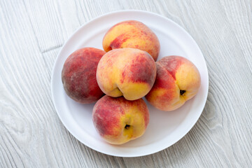 Fototapeta na wymiar A few ripe peaches lie on a plate