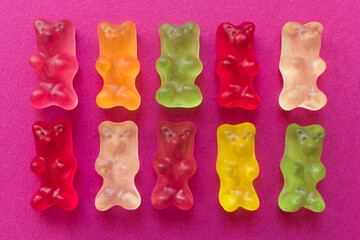 
Multi-colored jelly bears on a pink background.