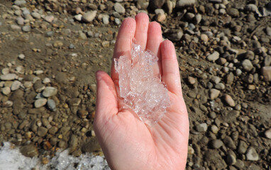 ice and melted snow in the palm of your hand  on a rocky background   