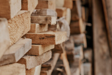 background and texture of beige wooden planks lying on top of each other in a stack in the woodshed