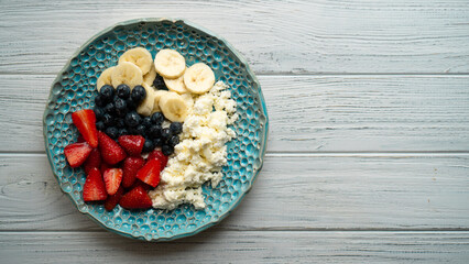 Healthy summer breakfast. Cottage cheese with strawberry blueberry banana and honey. Beautiful breakfast
