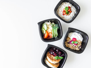 Healthy breakfast delivery. Fitness food. Eat right concept, healthy food, clean food take away in boxes, fried egg and vegetables, oatmeal, granola, cheesecakes on table close up