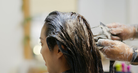 Fototapeta premium Woman dye her hair at beauty salon