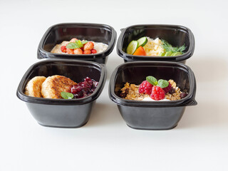 Healthy breakfast delivery. Fitness food. Eat right concept, healthy food, clean food take away in boxes, fried egg and vegetables, oatmeal, granola, cheesecakes