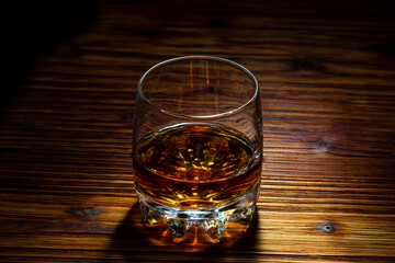 Glass of cognac on a wooden table.