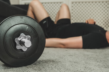 Man resting between exercise sets. Home fitness training concept.
