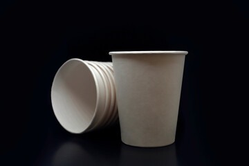 Paper textured white blank disposable cups for drinks to go, take away at black isolated background