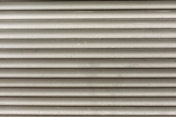 old shabby roller shutters designed to protect windows from vandals on a dark street