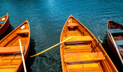 Tourist wooden boats moored by the shore - clear blue water - holiday attraction - boats for rent