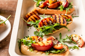 Grilled vegetarian baguette  sandwiches with arugula, grilled peach, black sesame and almond