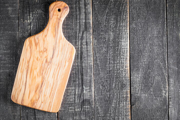 Wooden Cutting Board with Fresh Herbs and Raw Vegetables on Rustic Wood Table. Top view. Cooking background.