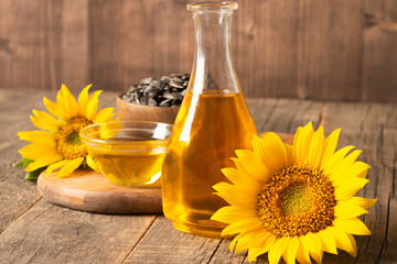 Closeup photo of sunflower oil with seeds on wooden background. Bio and organic product concept.