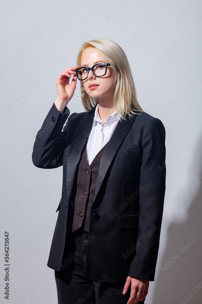 Poster beautiful blonde businesswoman in suit on gray background