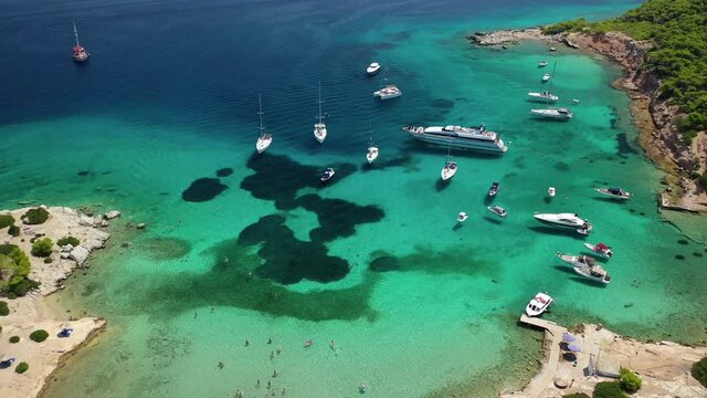 Aerial drone video of secluded paradise bay and small island of Moni with turquoise crystal clear beach next to Aigina, Saronic gulf, Greece