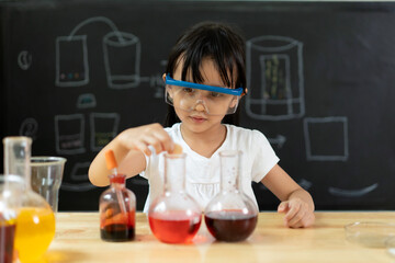 Adorable asian little girl is make easy scientific experimental at home, concept of learn from...