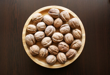 Wooden plate with walnuts.