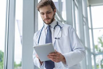 male medical doctor using tablet computer in hospital. - Powered by Adobe