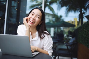 Happy Asian woman with laptop.