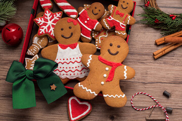 close up of gingerbread men in box and christmas decorations on wooden table.