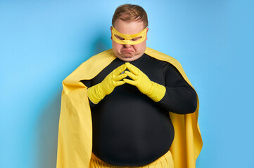 young caucasian cunning fat man conceived somethnig, he is looking down, wearing yellow costume and...
