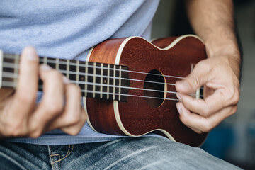 Fototapeta premium Close up Young man playing ukulele