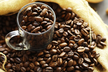 Bag of coffee. Coffee beans roasted on the table. Coffee beans with green leaves for cooking.