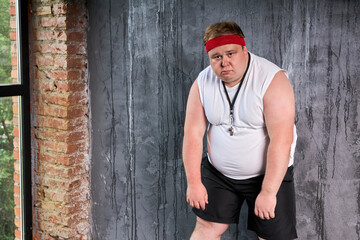 dolorous fat caucasian man with whistle in mouth, man tired doing sport exercises. isolated gray...