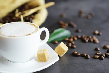 Bag of coffee. Coffee beans roasted on the table. Coffee beans with green leaves for cooking.