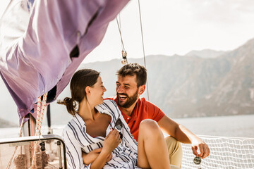 Loving couple spending happy time on a yacht at sea. Luxury vacation on a seaboat.