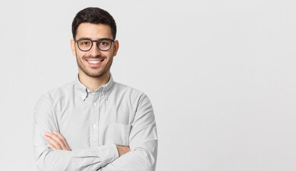 Banner of business man wearing gray shirt and glasses, standing with arms crossed, smiling happily and feeling confident, isolated with copy space on right