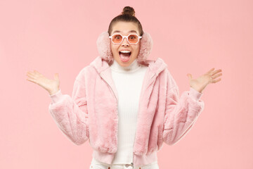 Young excited teen girl wearing winter fur coat, spreading arms in  surprise emotion, isolated on...