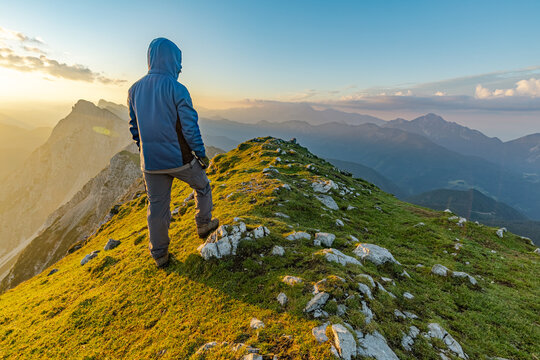 A man enjoying the view from the top of Veliki vrh mountain on the Kosuta ridge mountain in the Karavanke range Alps, Slovenia