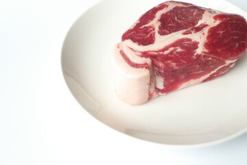 豚肩ロースのブロックと白い皿