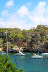 View of the Bay of Cala Figuera with yachts and sailboats against a blue sky with clouds. Majorca. Spain.