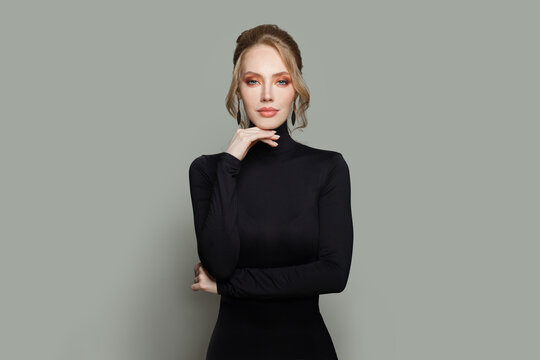 Elegant model woman wearing black turtleneck sweater standing against gray wall background
