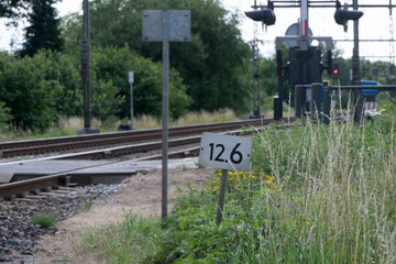A train number sign with train light / stop in the background