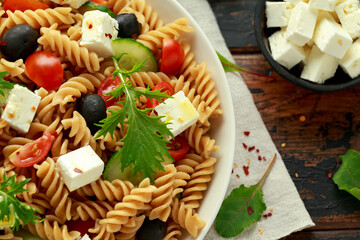 Pasta salad with tomato, black olives, cucumber and feta cheese. healthy food.