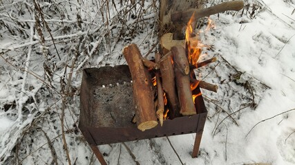 burning firewood. fire lit against snow in winter