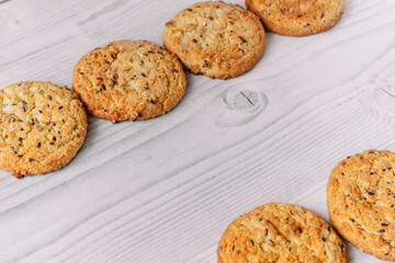 Frame composition of chocolate chip and oatmeal cookies on white wood table background with copy space. Image use for commercial or menu layout design. Winter, autumn, kitchen. Flat lay.