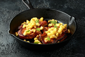 Roasted Pork chops with caramelized apples, walnuts and sage in a cast iron pan