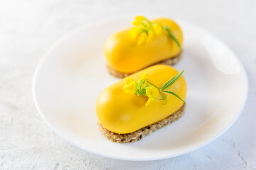 Vegan mousse cashew and sea buckthorn cakes on a white plate. No sugar, gluten, lactose.