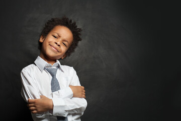 Smart funny black child boy in white shirt and tie on black background