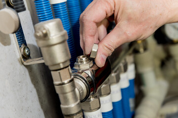 Heating engineer fixing modern heating system in boiler room. 