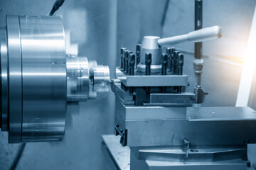 The operation of lathe machine cutting the brass shaft parts with the cutting tools. The metalworking process by turning machine.