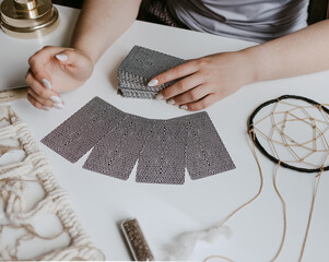 woman holding in her hands tarot cards